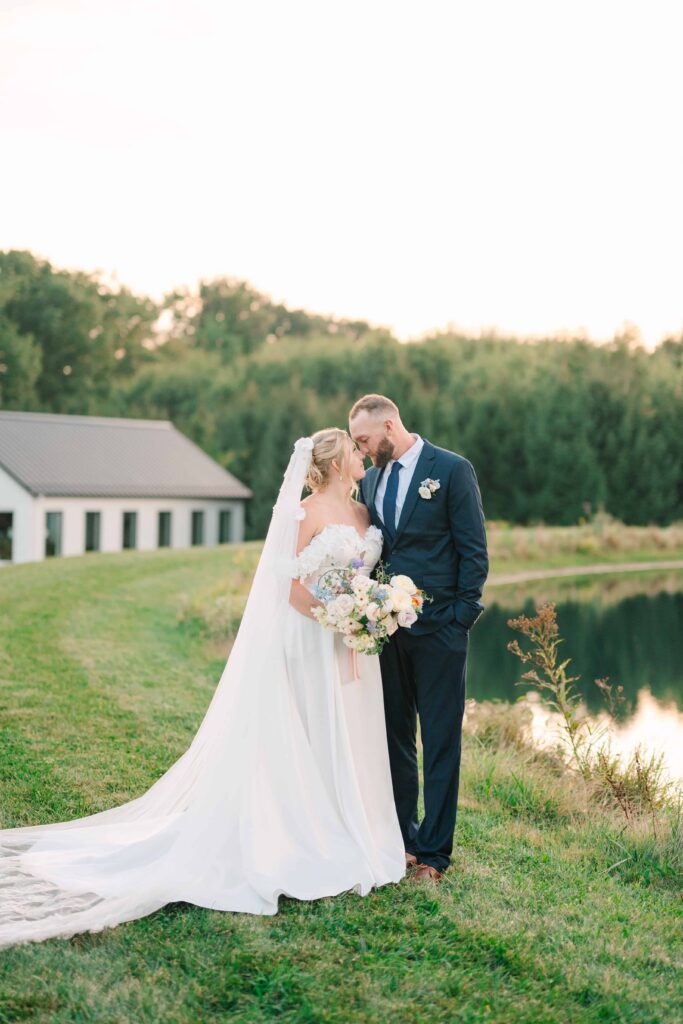 Bride and groom in navy suit standing outside The Wellspring on their wedding day