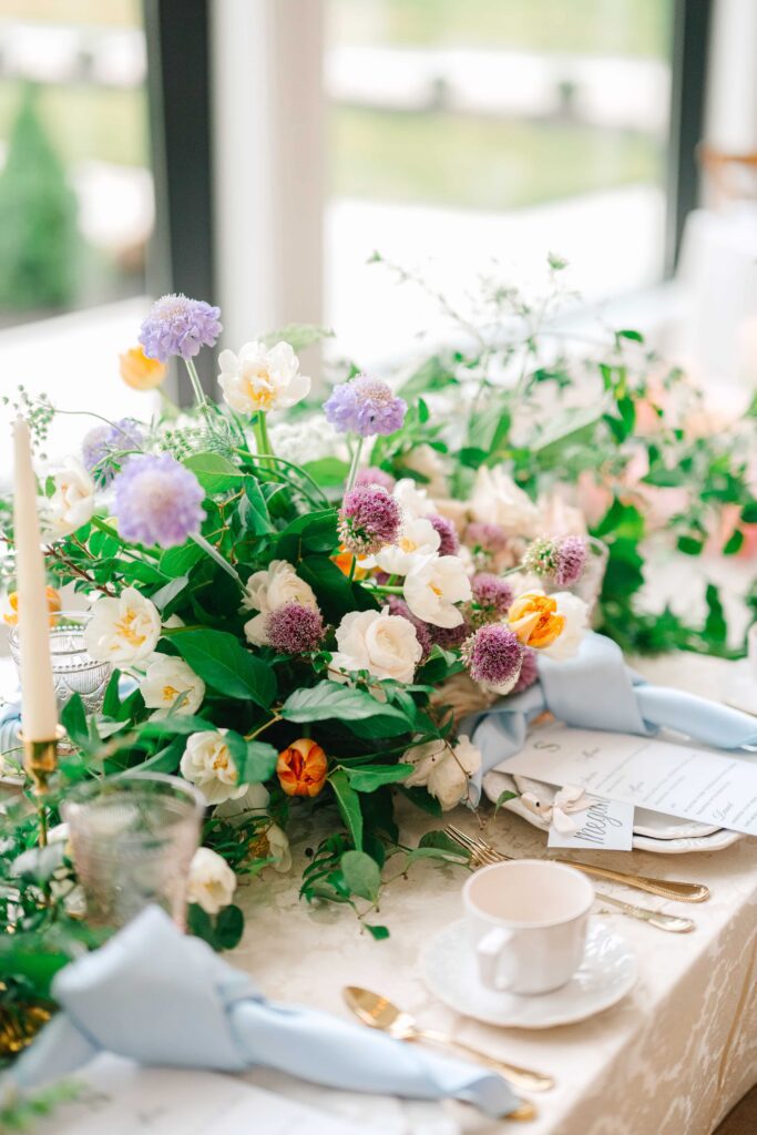 Purple wedding flowers and light blue napkins for a wedding tablescape